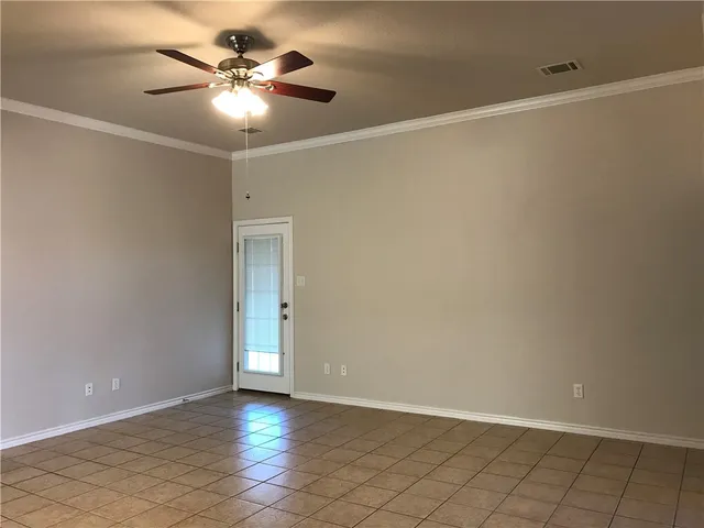 an empty room with a ceiling fan and carpet