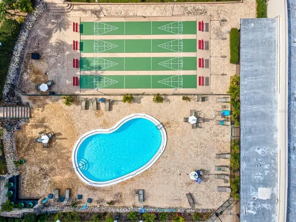 a view of a tennis ground with large trees