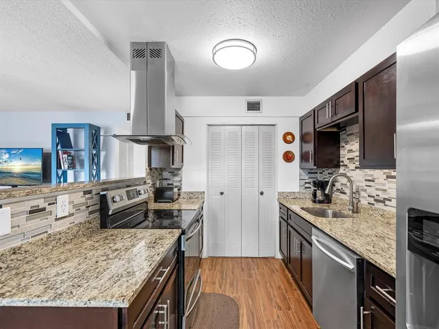 a kitchen with stainless steel appliances granite countertop a sink stove and refrigerator