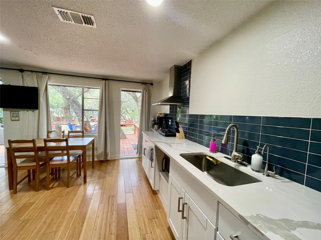 17357 West Beach Road Austin, TX 78734 - Photo 11 of 32 a kitchen with a sink a stove and wooden floor