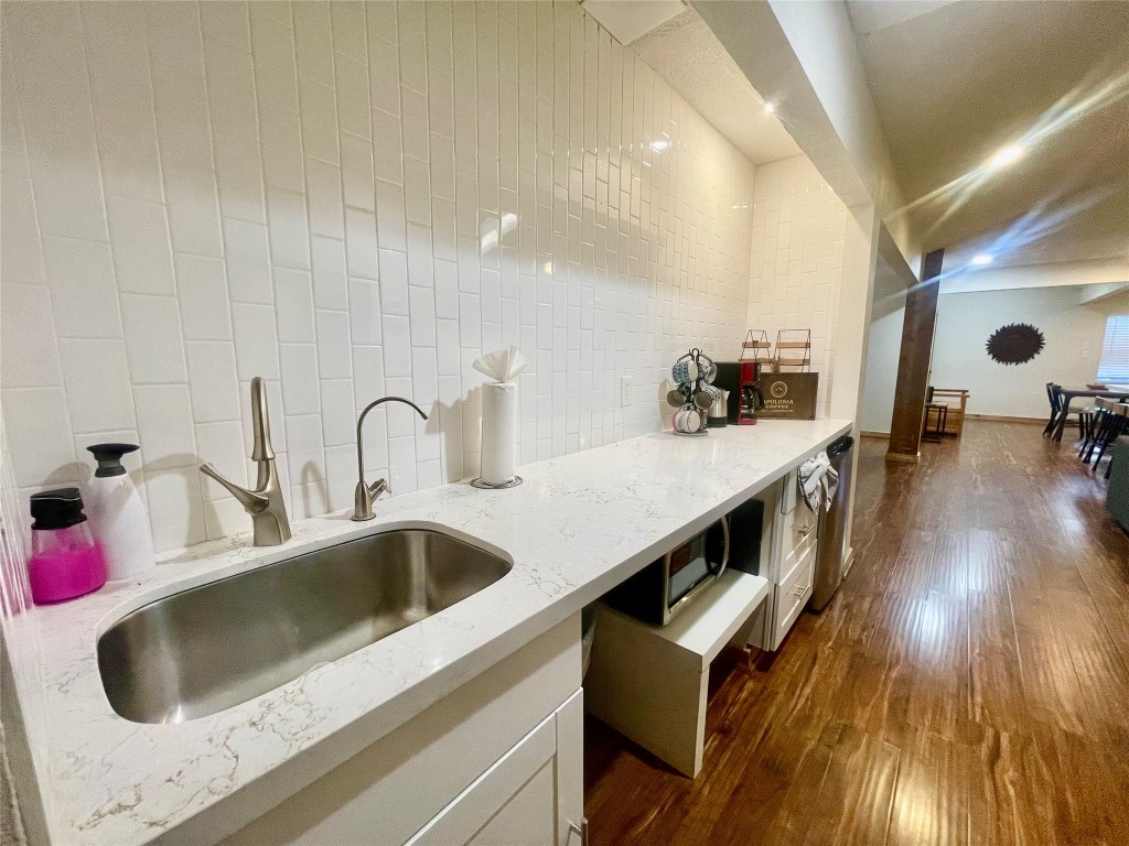 17357 West Beach Road Austin, TX 78734 - Photo 15 of 32 a kitchen with kitchen island a stove a sink and dishwasher with wooden floor