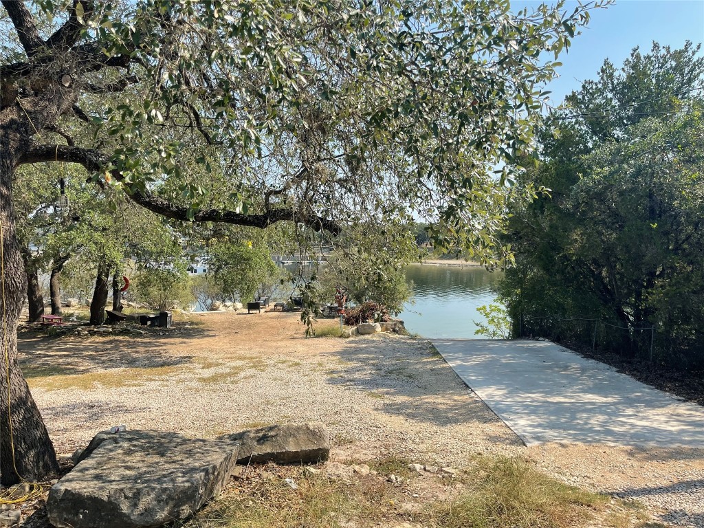 17357 West Beach Road Austin, TX 78734 - Photo 28 of 32 a backyard of a house with large trees and outdoor seating