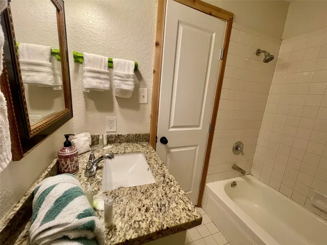a bathroom with a tub sink and a mirror