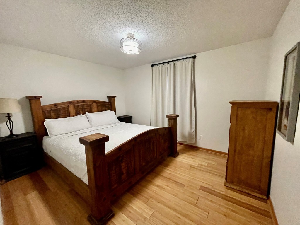 17357 West Beach Road Austin, TX 78734 - Photo 9 of 32 a bedroom with bed and wooden floor