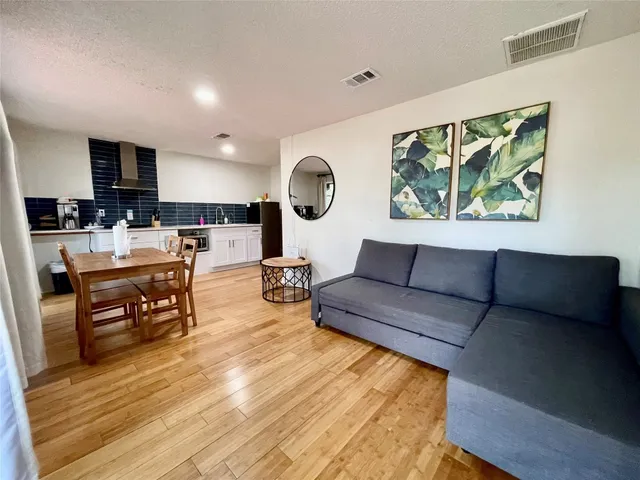 a living room with furniture and a wooden floor