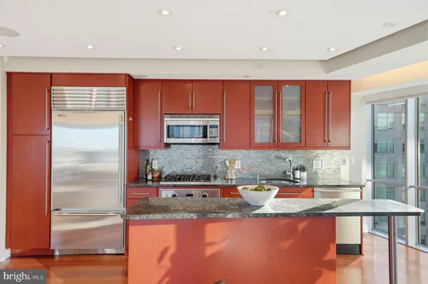 a kitchen with stainless steel appliances granite countertop a sink and a refrigerator