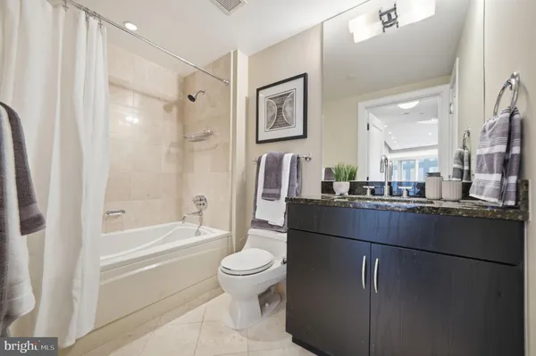 a bathroom with a bathtub shower sink vanity and toilet