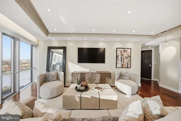a living room with furniture a flat screen tv and a large window