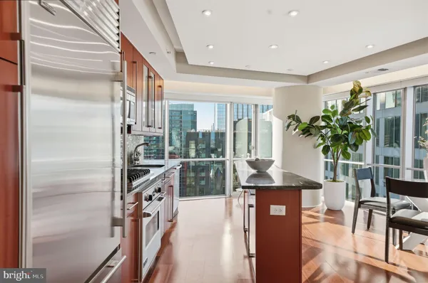 a kitchen with granite countertop a refrigerator and a plant