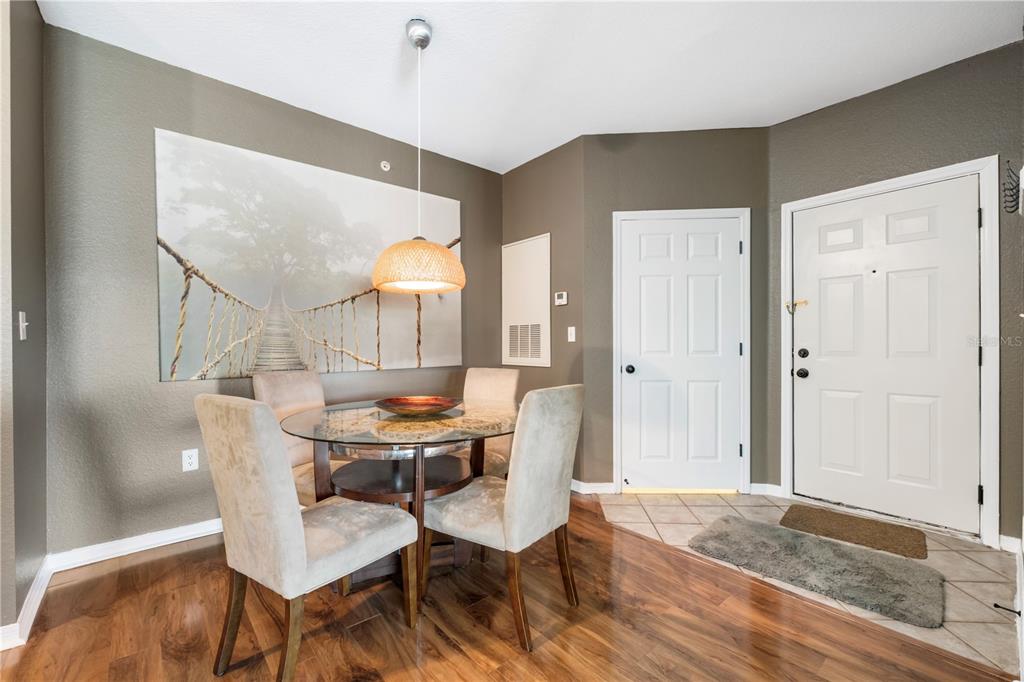 5475 Vineland Road, Unit 8302 Orlando, FL 32811 - Photo 3 of 12 a dining room with furniture and wooden floor