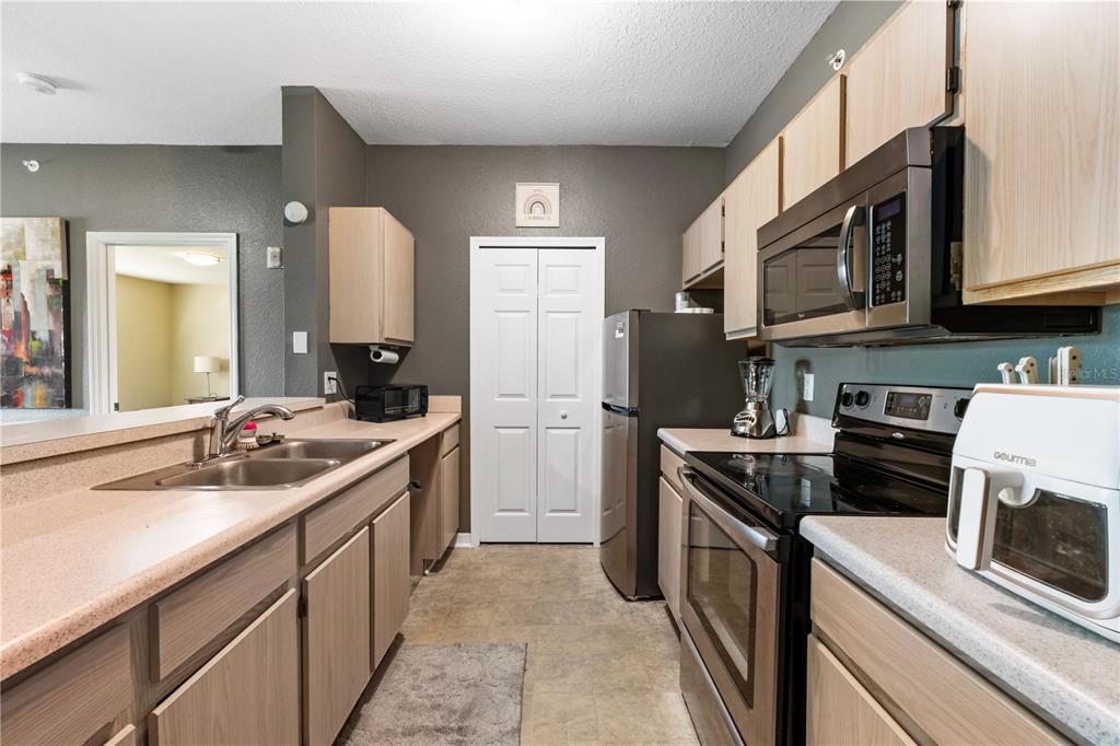5475 Vineland Road, Unit 8302 Orlando, FL 32811 - Photo 6 of 12 a kitchen with a sink stove and refrigerator