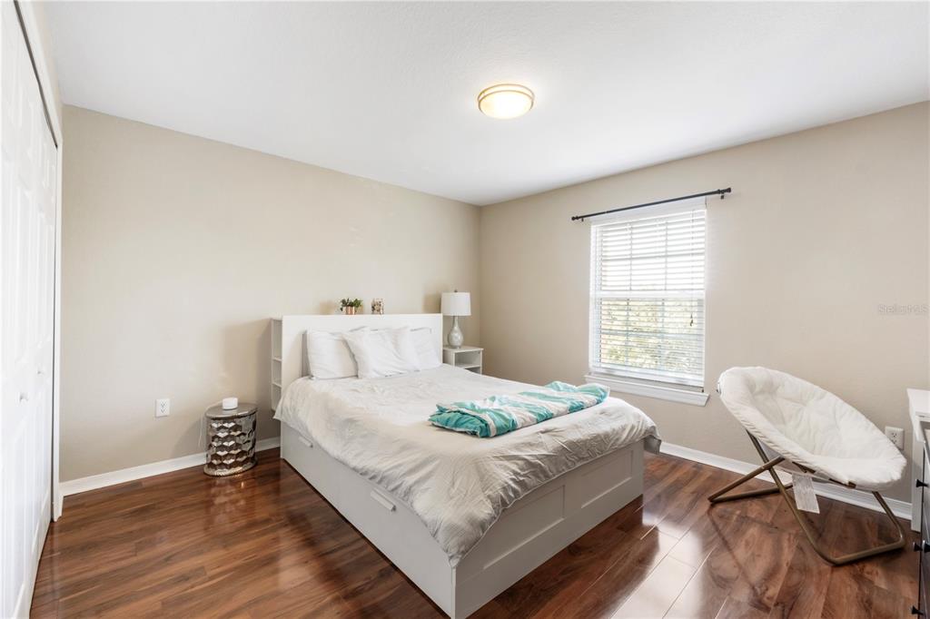 5475 Vineland Road, Unit 8302 Orlando, FL 32811 - Photo 10 of 12 a bedroom with a bed a chair and a window