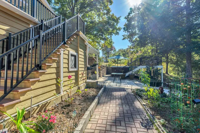 an aerial view of residential house with outdoor space and trees all around