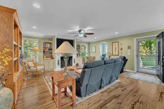 a living room with furniture a large window and wooden floor