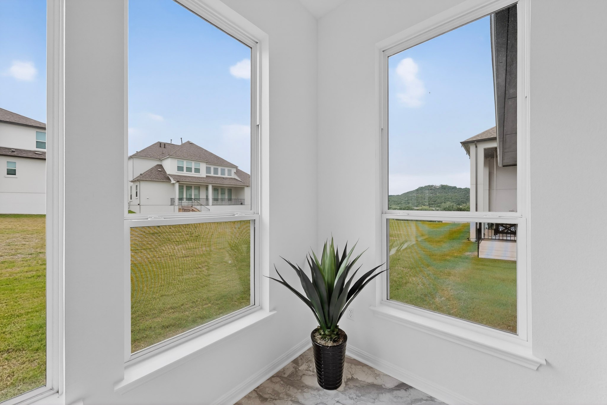 2308 Mondello Path Leander, TX 78641 - Photo 13 of 39 Corner window placement creates a well-lit nook, offering scenic views of the surrounding neighborhood and distant hills.