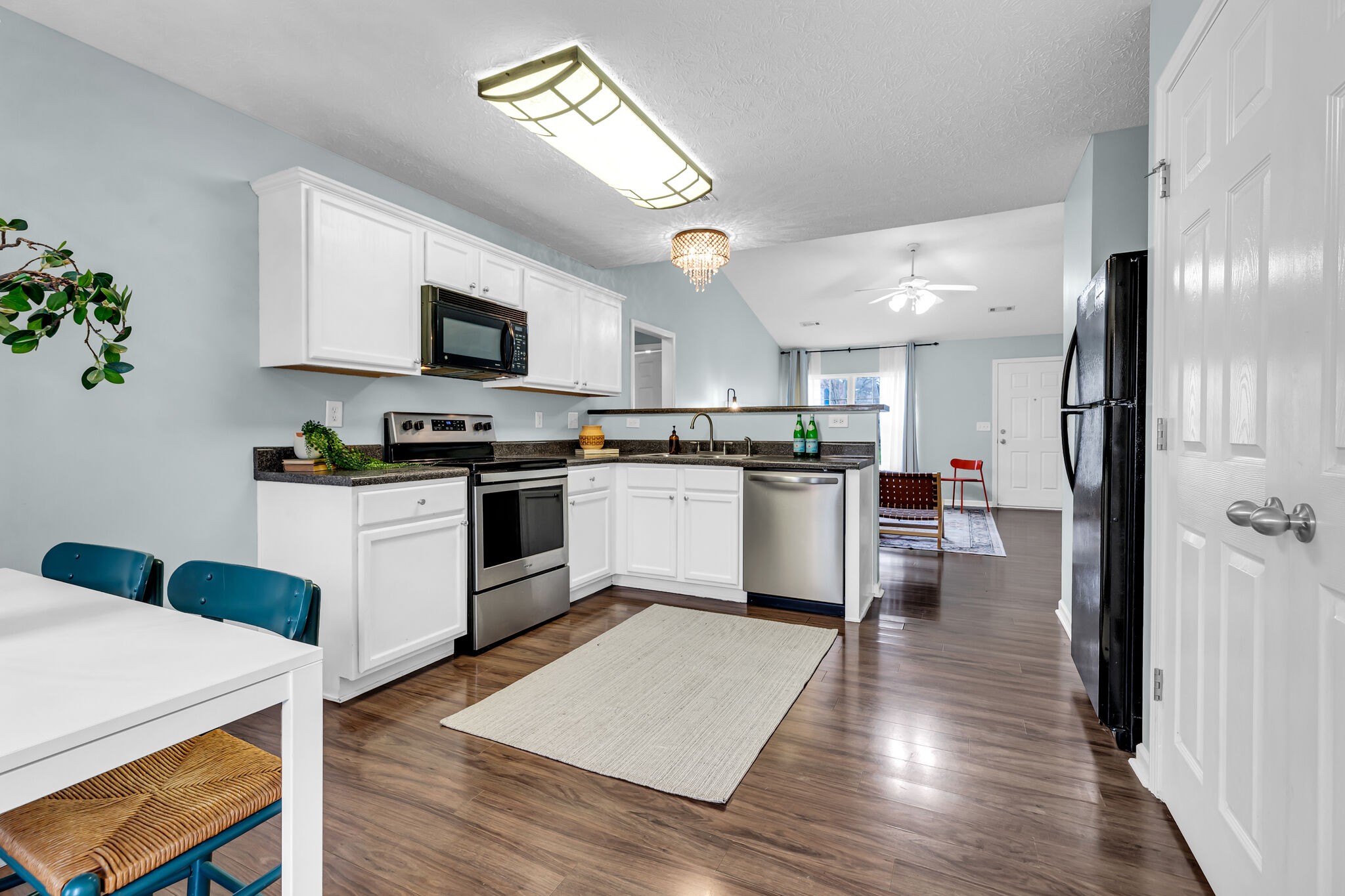 4026 Deer Run Trace Spring Hill, TN 37174 - Photo 14 of 29 a kitchen with granite countertop a refrigerator a stove top oven a sink dishwasher and white cabinets with wooden floor