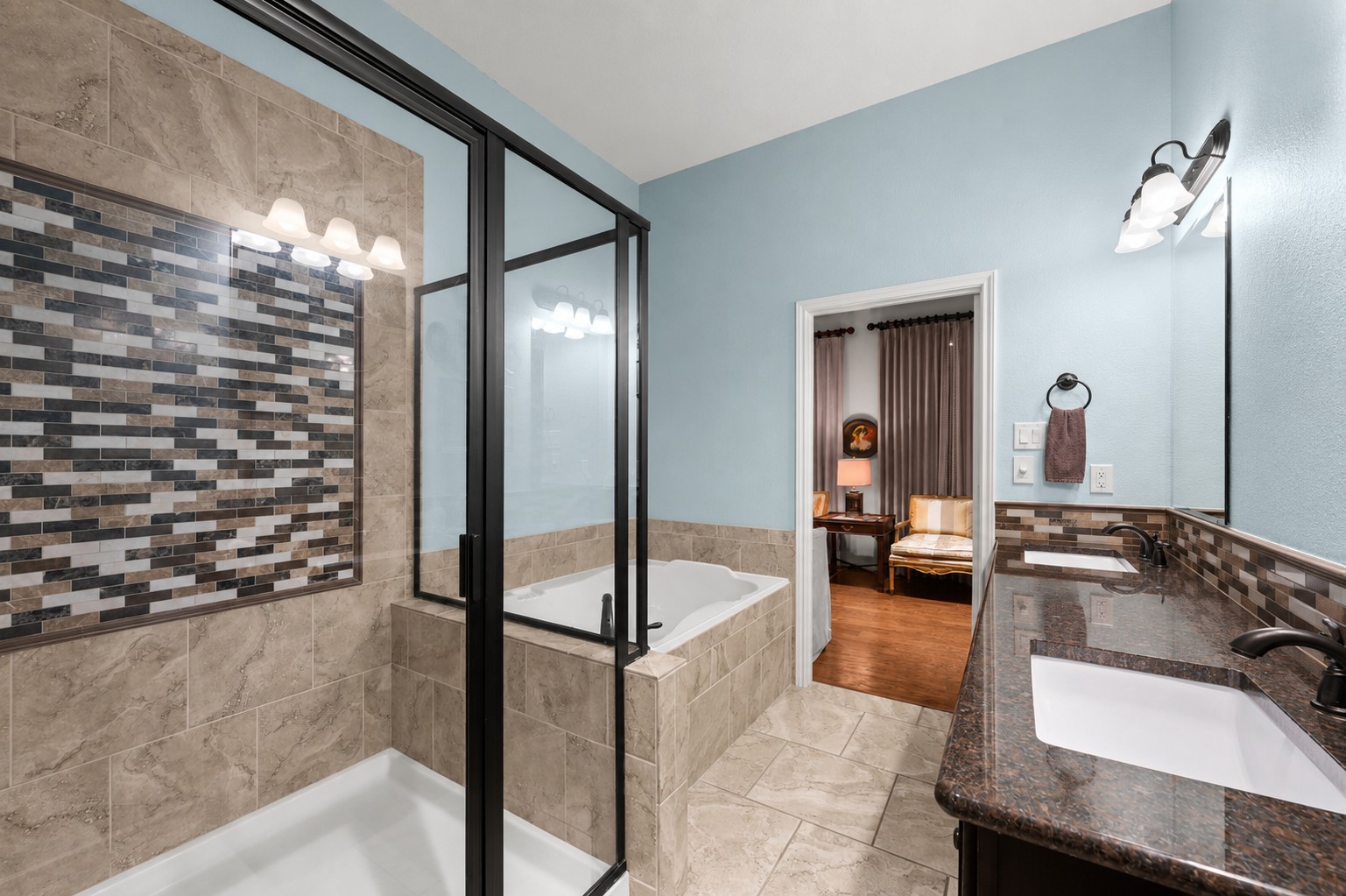 204 Adams Street Georgetown, TX 78628 - Photo 22 of 33 The bathroom features a tiled shower with a clear glass enclosure, alongside a separate soaking tub and a vanity with dual sinks.