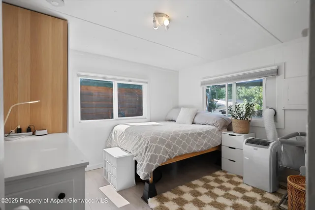 a bedroom with a bed and a large window