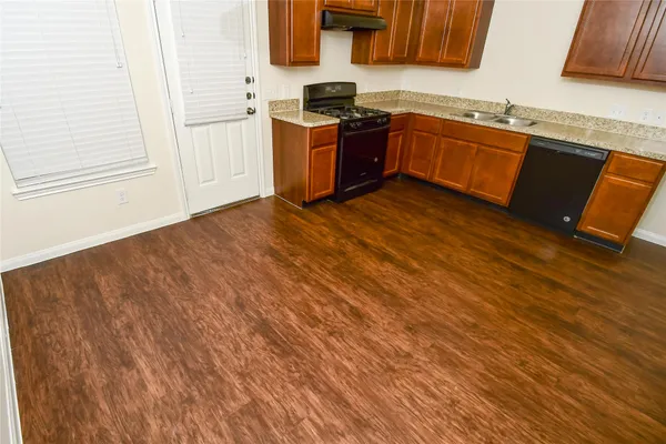 a kitchen with granite countertop a sink cabinets and stainless steel appliances