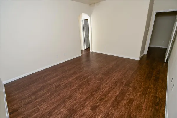 an empty room with wooden floor and mirror