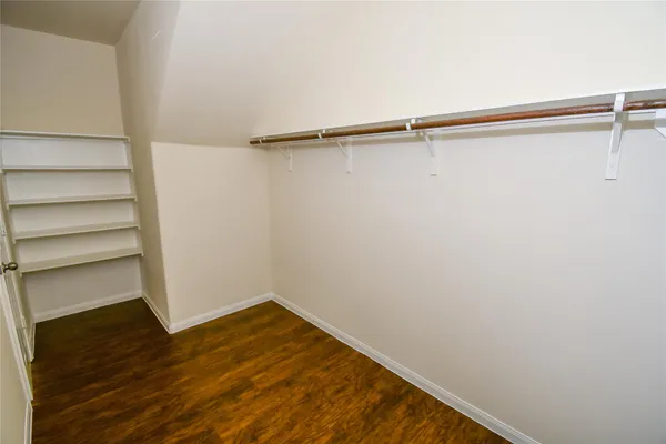 a view of a room with wooden floor and small window