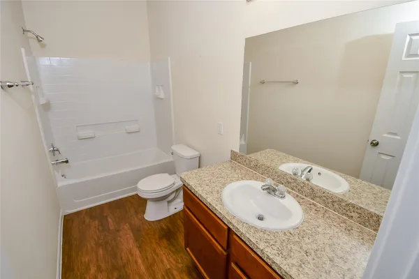 a bathroom with a granite countertop sink toilet a mirror and shower