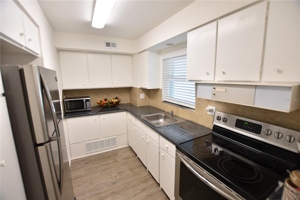 3900 Roxane Boulevard, Unit 10A Sarasota, FL 34235 - Photo 2 of 10 a kitchen with a stove microwave and a refrigerator