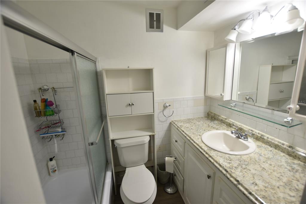 3900 Roxane Boulevard, Unit 10A Sarasota, FL 34235 - Photo 7 of 10 a bathroom with a granite countertop toilet sink and mirror