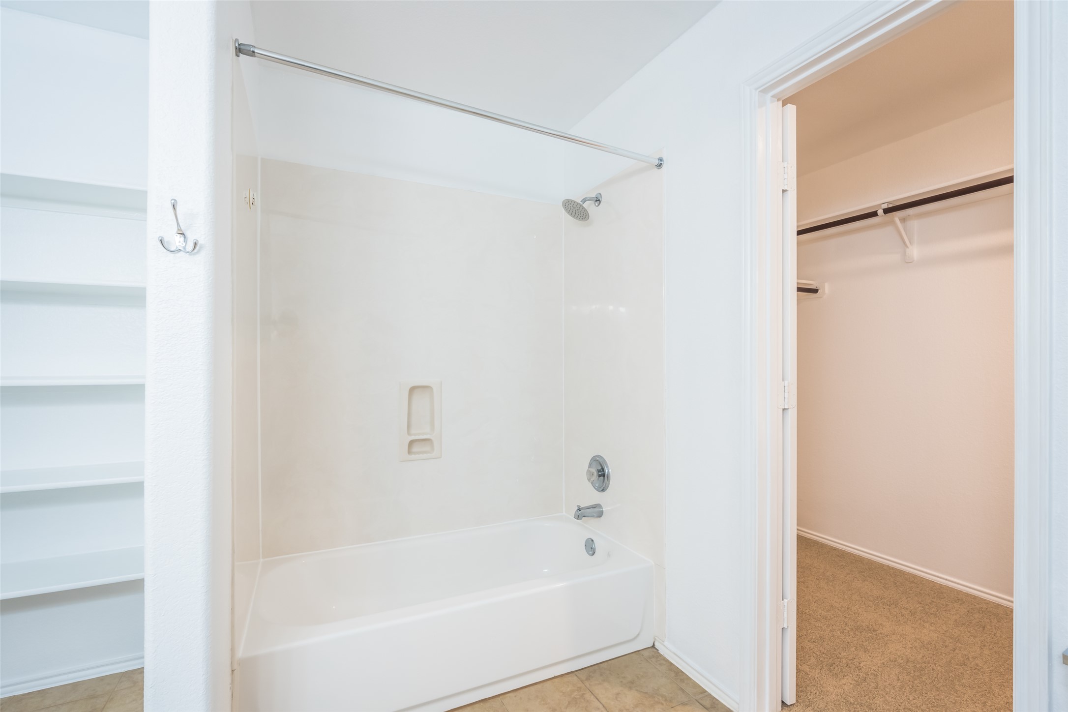 1013 Ranchero Road Leander, TX 78641 - Photo 25 of 30 A classic bathtub shower combination sits adjacent to a built-in linen closet and walk-in wardrobe.