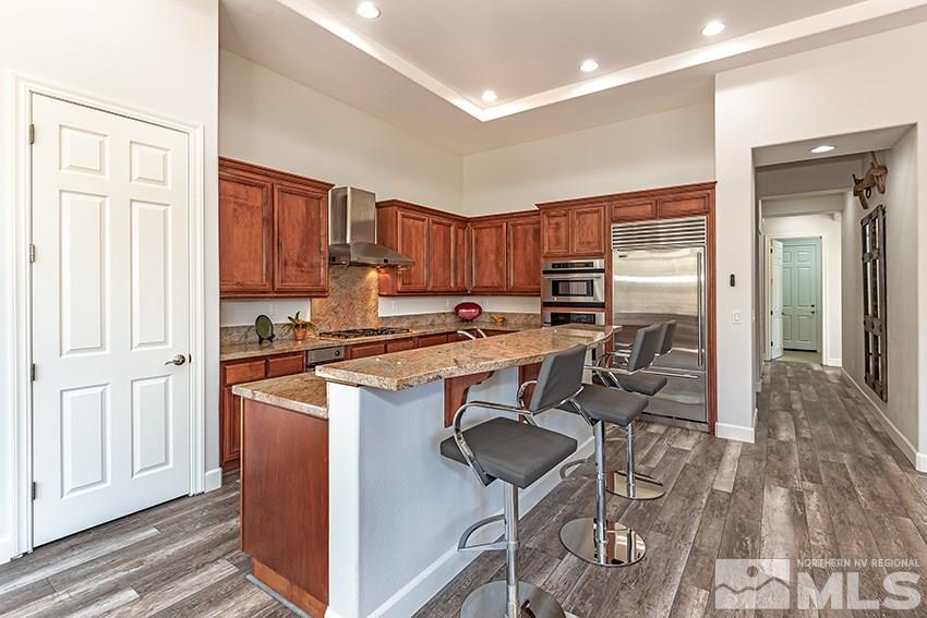 2675 Colmar Court Reno, NV 89521 - Photo 10 of 25 a kitchen with stainless steel appliances granite countertop a stove top oven a refrigerator and cabinets