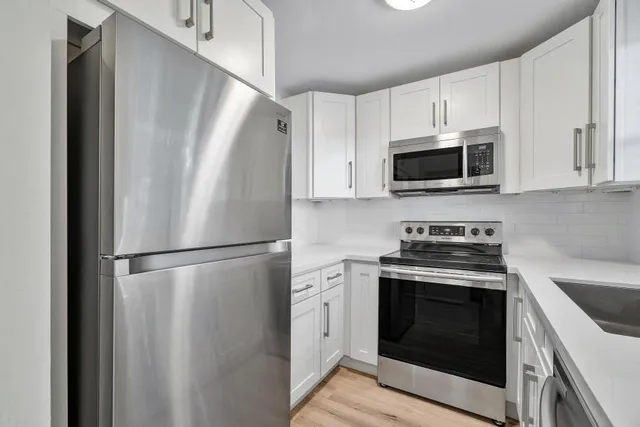 a white refrigerator freezer a stove top oven sitting inside of a kitchen