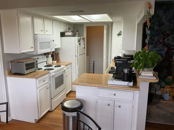 a kitchen with white cabinets and white appliances