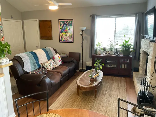 a living room with furniture a flat screen tv and a large window