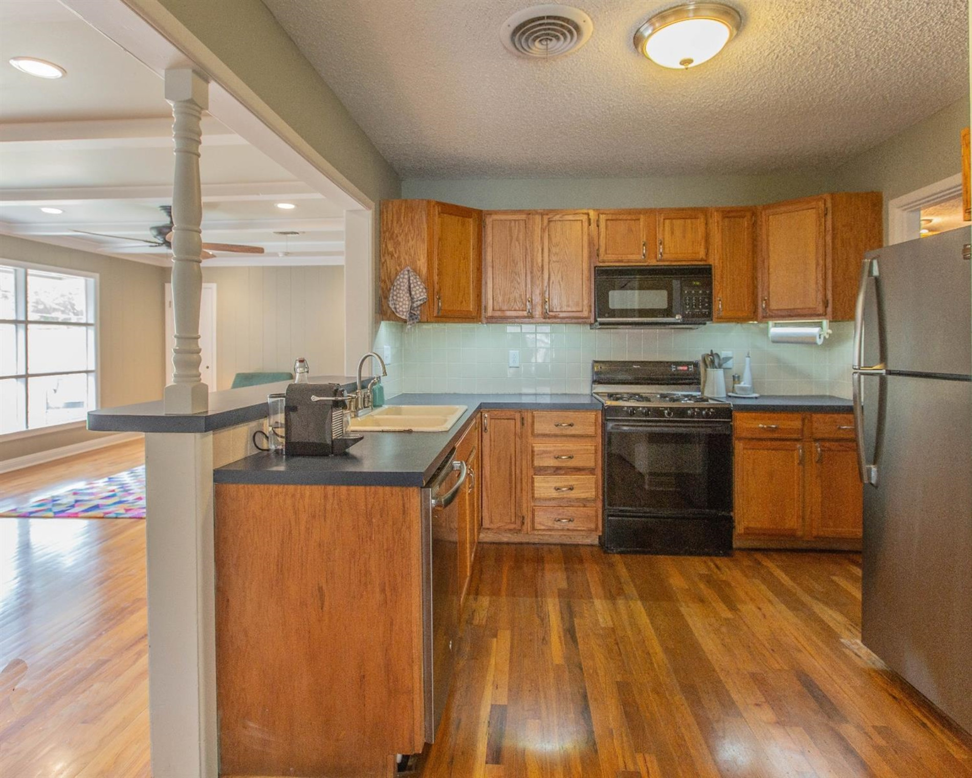 3204 26th Street Lubbock, TX 79410 - Photo 3 of 10 a kitchen with stainless steel appliances granite countertop a stove a sink dishwasher and a refrigerator