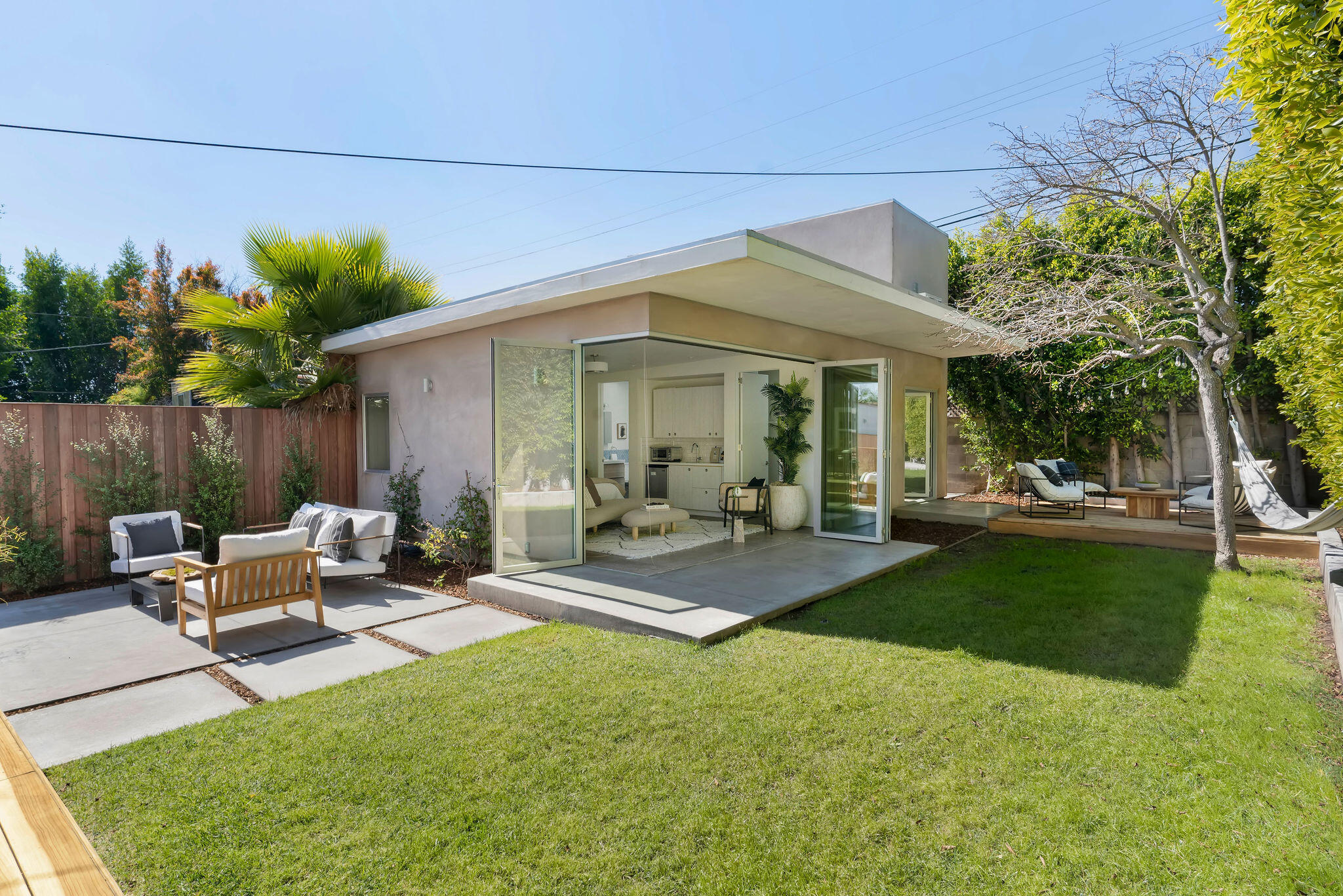 1317 Keniston Avenue Los Angeles, CA 90019 - Photo 1 of 57 a view of a patio with table and chairs potted plants and large tree