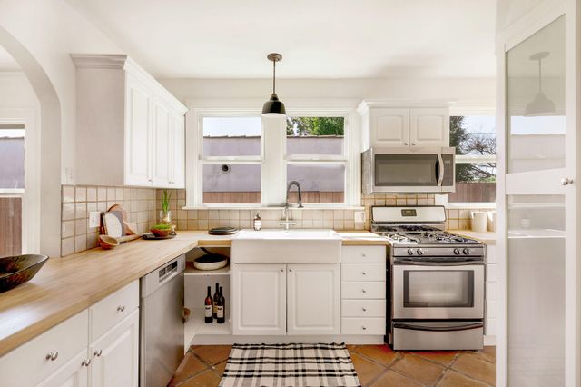 a stove top oven sitting inside of a kitchen