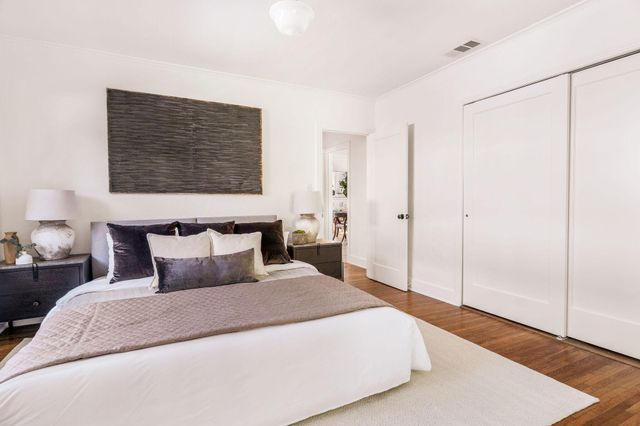 a bedroom with a bed and a painting on the wall