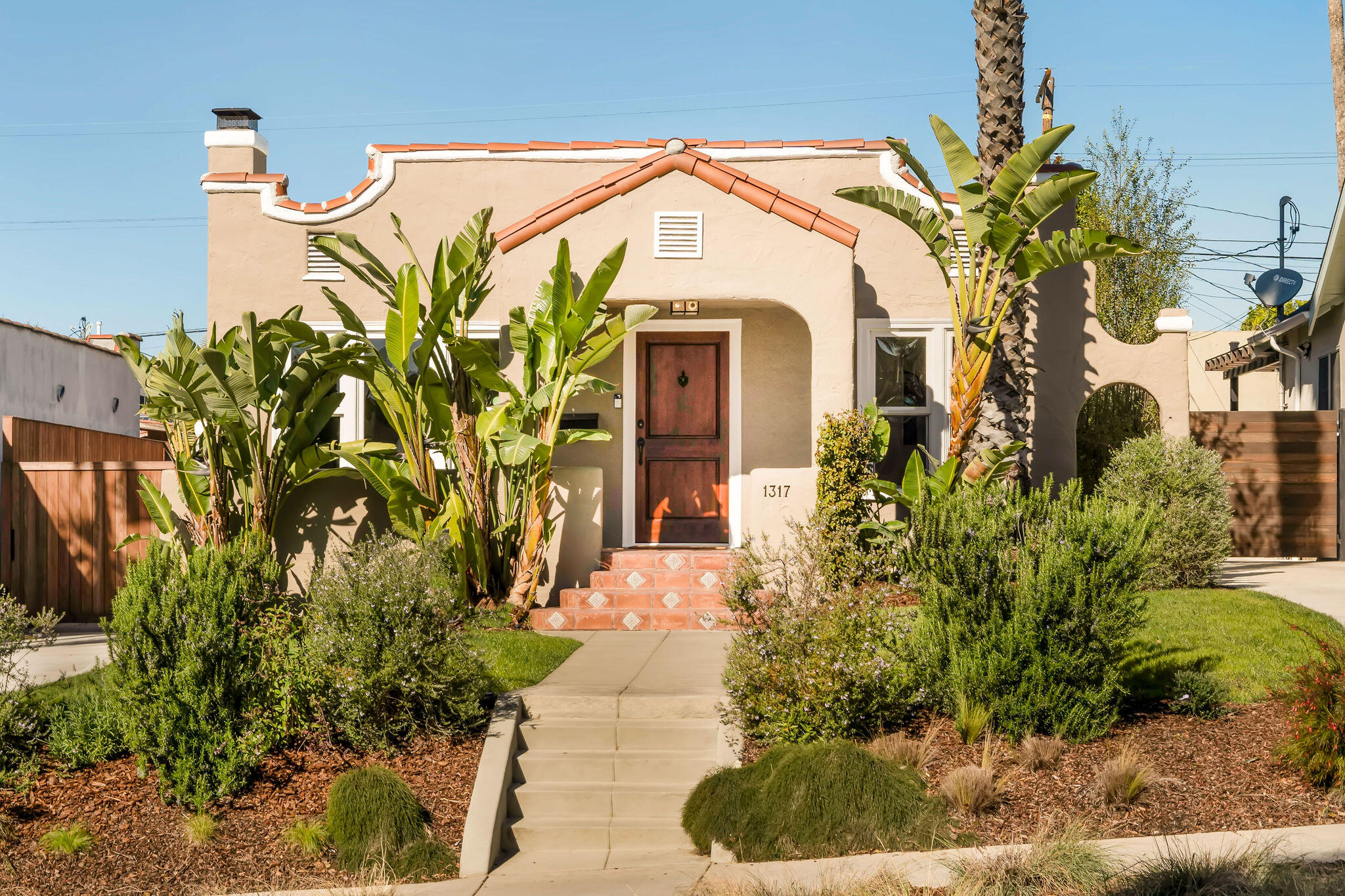 1317 Keniston Avenue Los Angeles, CA 90019 - Photo 3 of 57 a front view of a house with a yard