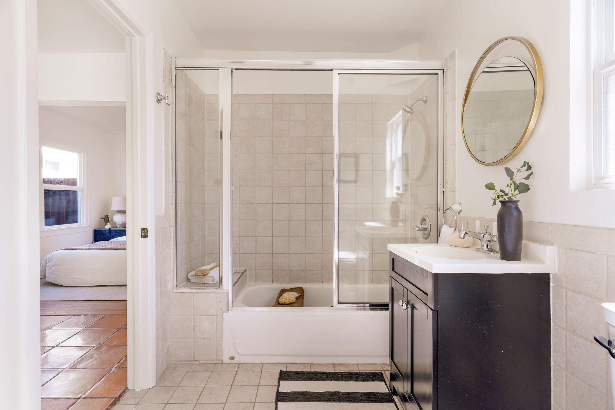 1317 Keniston Avenue Los Angeles, CA 90019 - Photo 33 of 57 a en suite bathroom with a sink a mirror and a shower
