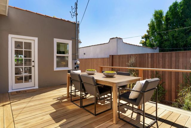 a view of a patio with table and chairs potted plants with wooden floor
