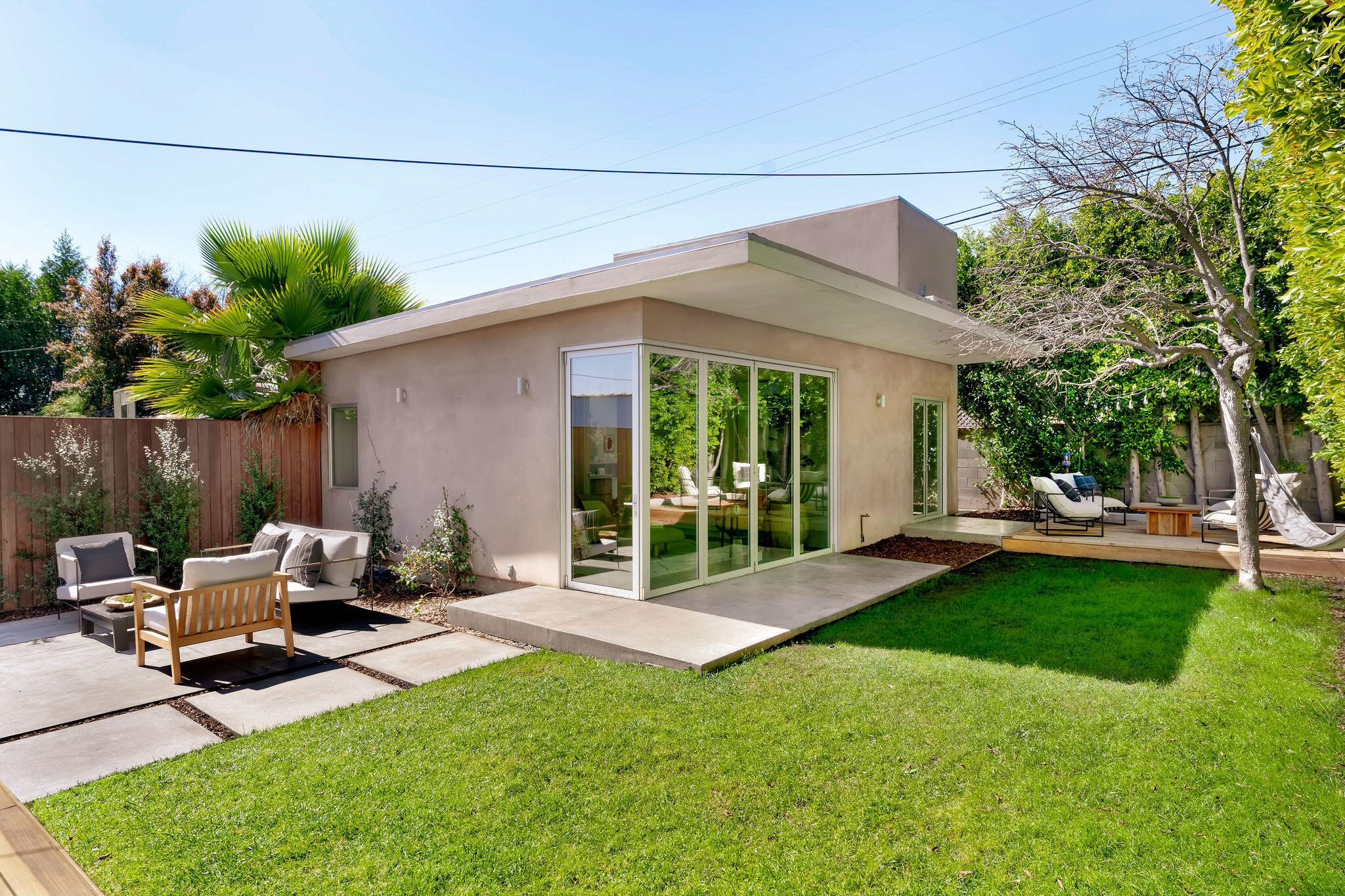 1317 Keniston Avenue Los Angeles, CA 90019 - Photo 39 of 57 a view of a patio with table and chairs and potted plants with wooden fence