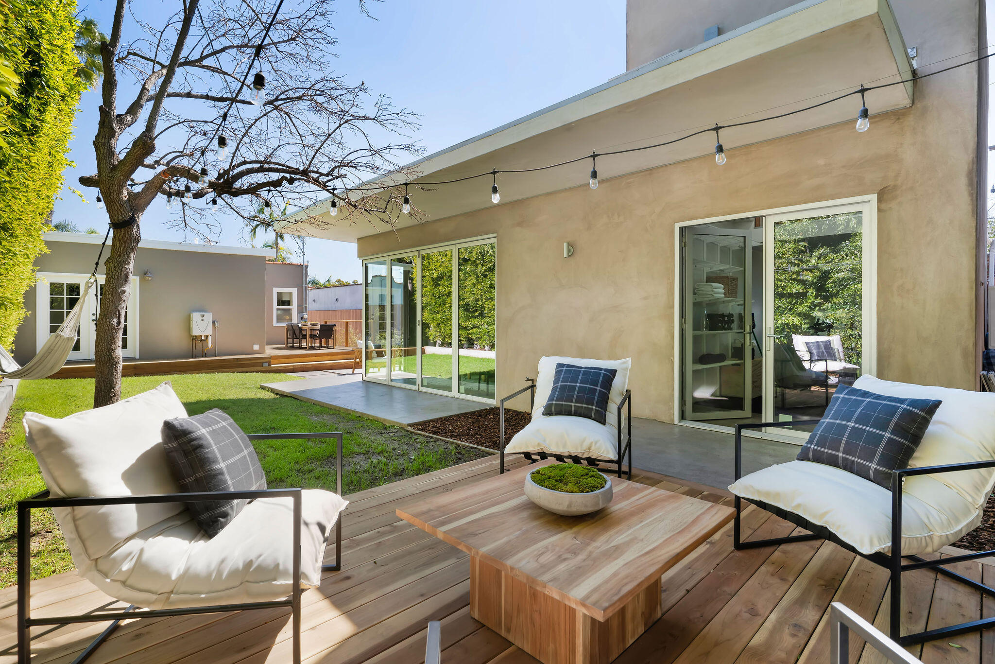 1317 Keniston Avenue Los Angeles, CA 90019 - Photo 52 of 57 a view of a patio with table and chairs potted plants and a large tree