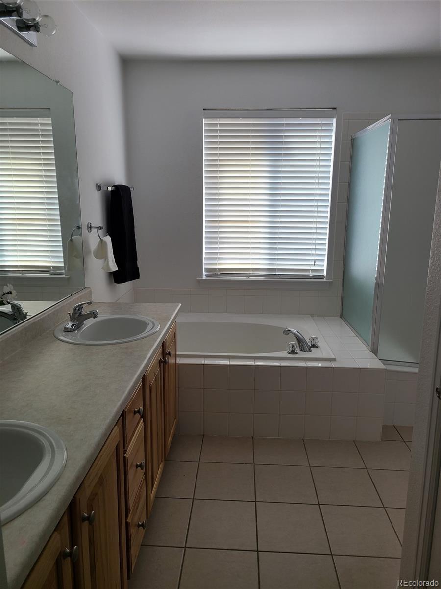 9492 Cedarhurst Lane, Unit B Highlands Ranch, CO 80129 - Photo 12 of 17 a bathroom with a granite countertop sink and a bathtub