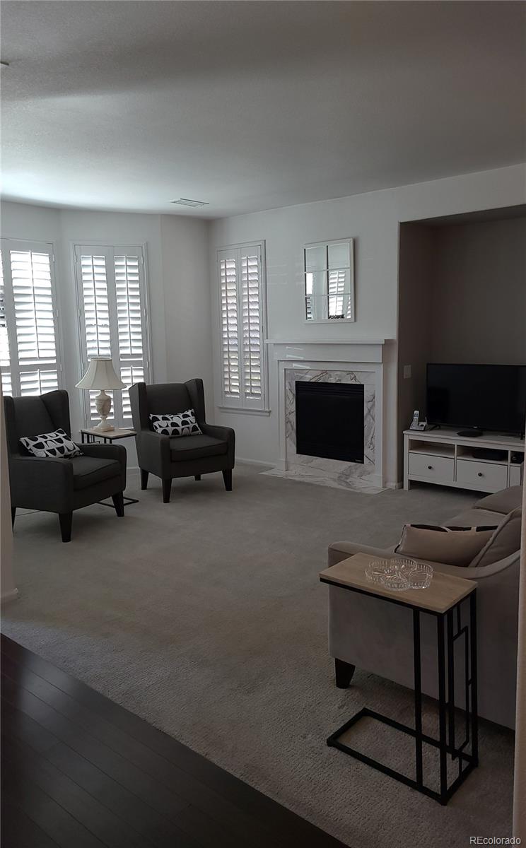 9492 Cedarhurst Lane, Unit B Highlands Ranch, CO 80129 - Photo 17 of 17 a living room with furniture a fireplace and a flat screen tv