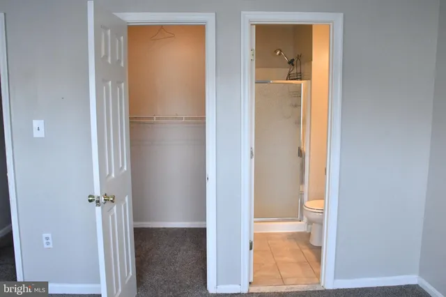 a bathroom with a tub shower and mirror