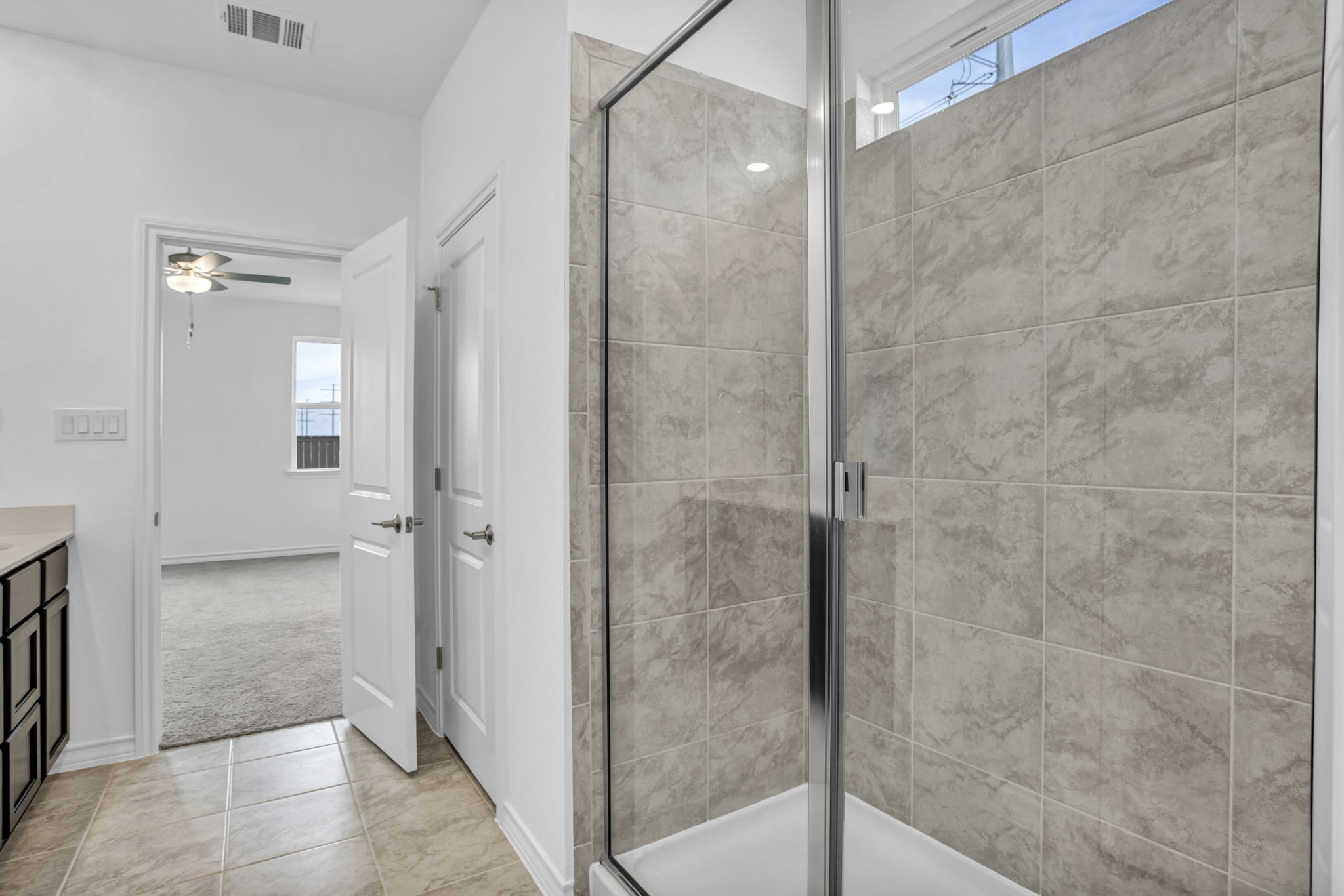 131 Adeline Road Hutto, TX 78634 - Photo 24 of 30 A well-appointed bathroom offers a convenient walk-in shower with sleek glass enclosure and tiled walls.