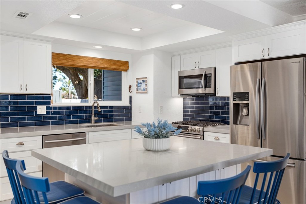 24562 Harbor View Drive, Unit 18 Dana Point, CA 92629 - Photo 1 of 33 a kitchen with stainless steel appliances a dining table chairs and refrigerator