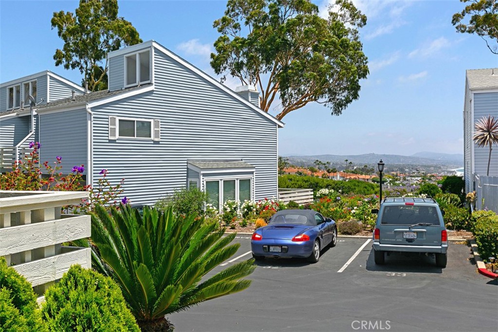 24562 Harbor View Drive, Unit 18 Dana Point, CA 92629 - Photo 33 of 33 a car parked in front of a white house with wooden fence