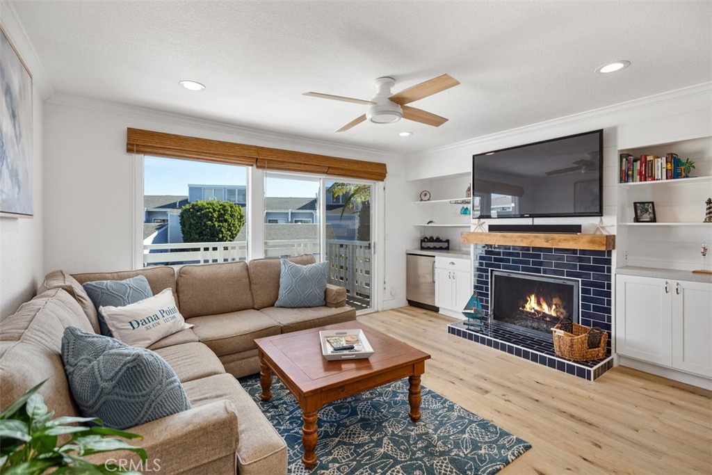 24562 Harbor View Drive, Unit 18 Dana Point, CA 92629 - Photo 5 of 33 a living room with furniture a flat screen tv and a fireplace