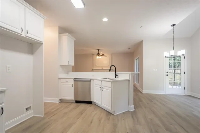 a kitchen with stainless steel appliances granite countertop a sink a stove a refrigerator and island with wooden floor